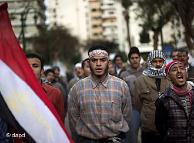 Protesters walking down street, Egyptian flag